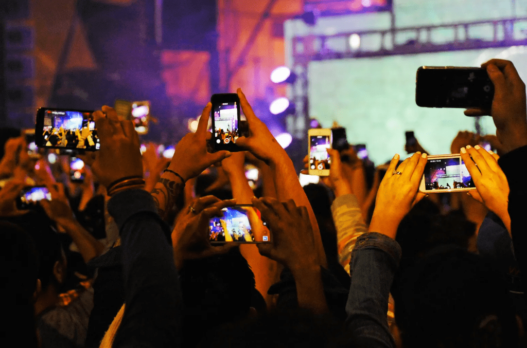 Phone screens lighting up concert scene built for social media sharing